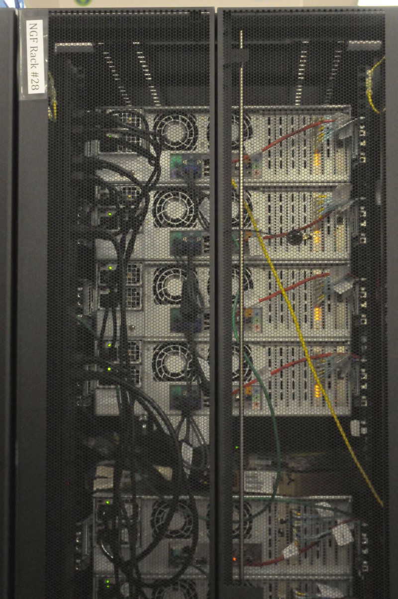 Rückseite eines Serverschranks mit Kabeln und mehreren Rechnern