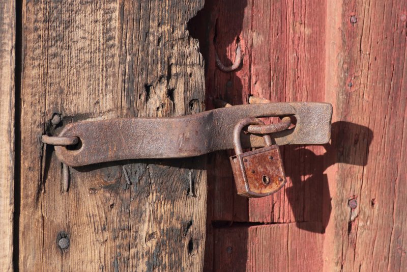 Metallisches Vorhängeschloss vor neutralem Hintergrund