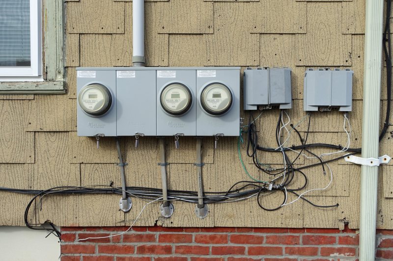 Mehrere technische Zähler und Leitungen an einer Hauswand