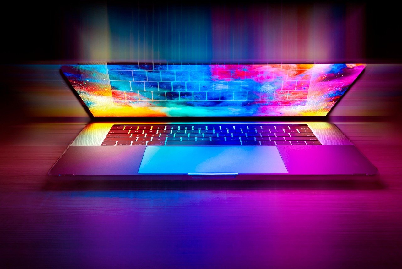 Geöffneter Laptop mit farbig beleuchtetem Bildschirm und Tastatur.