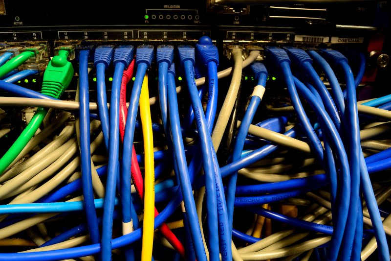 Mehrere farbige Netzwerkkabel stecken in einem Ethernet-Verteiler