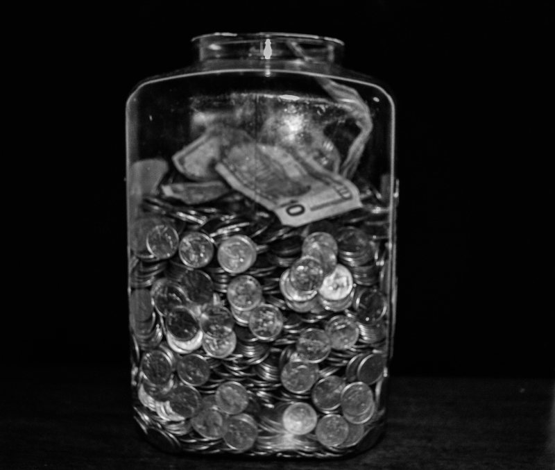 Glas mit Münzen als Symbol für Kosten virtueller Spielwährungen