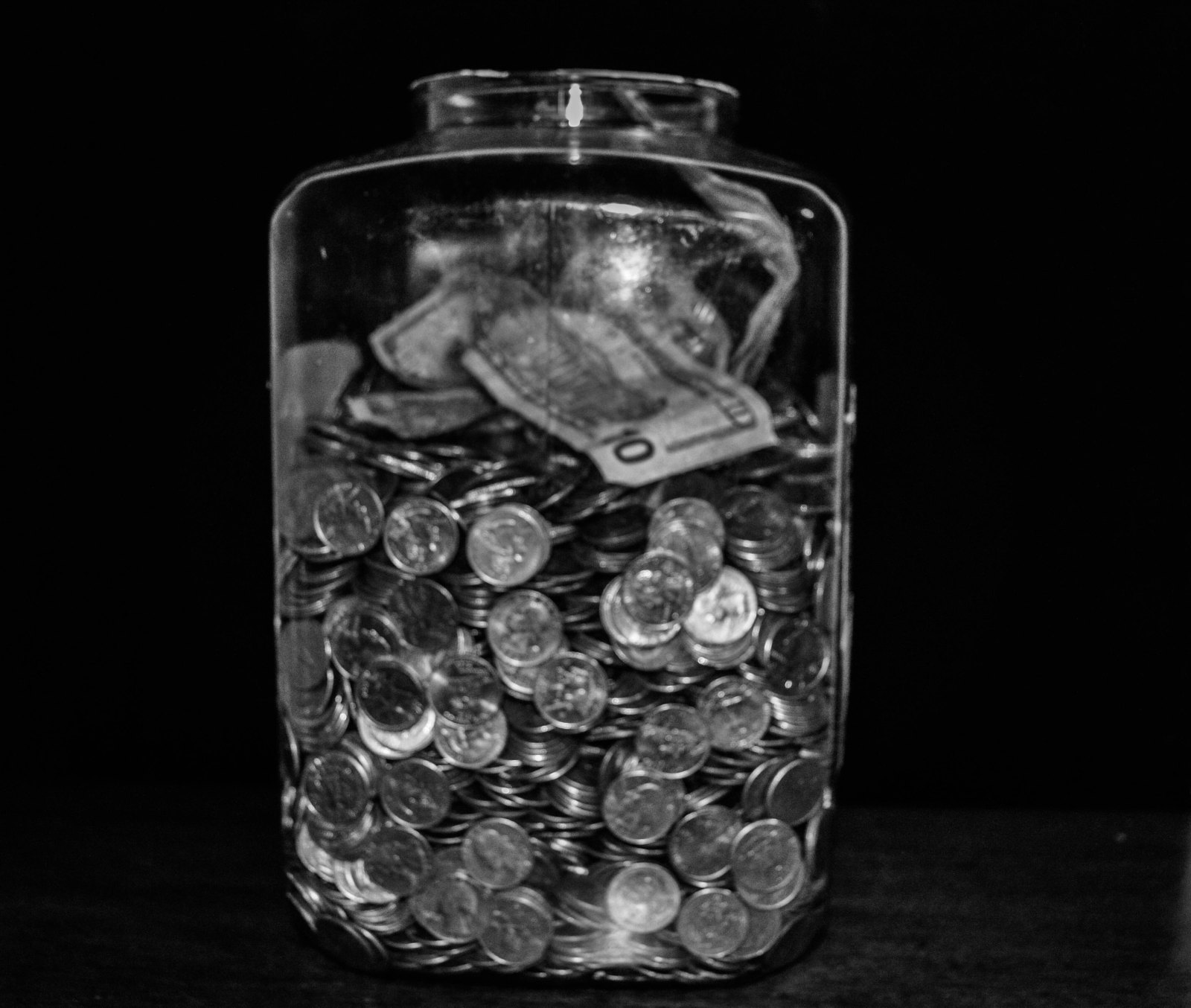 Glas mit Münzen als Symbol für Kosten virtueller Spielwährungen