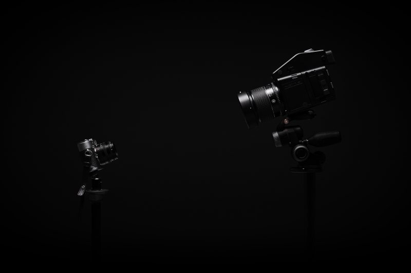 Fotoapparat und Videokamera auf einer hellen Fläche