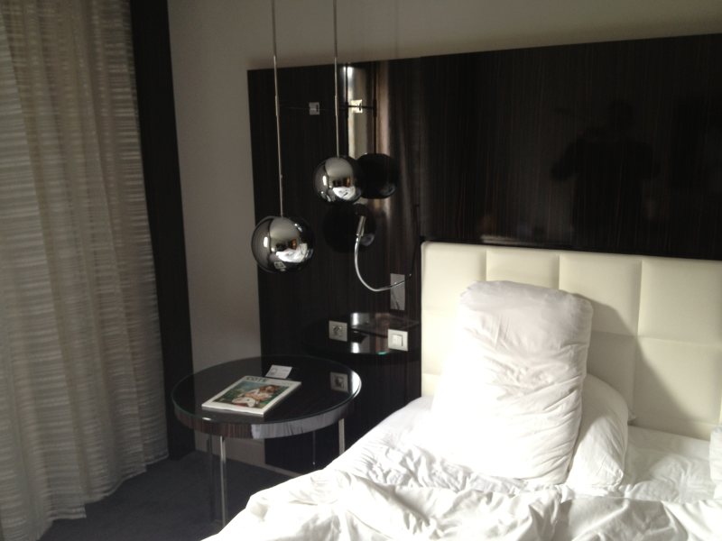 Ein aufgeräumtes Hotelzimmer mit Bett und Lampen